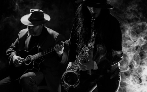 Black and white image of Sax and Guitar player in smokey room